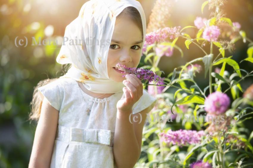 Young girl enjoying flowers in a sunlit garden while wearing a scarf on a warm afternoon